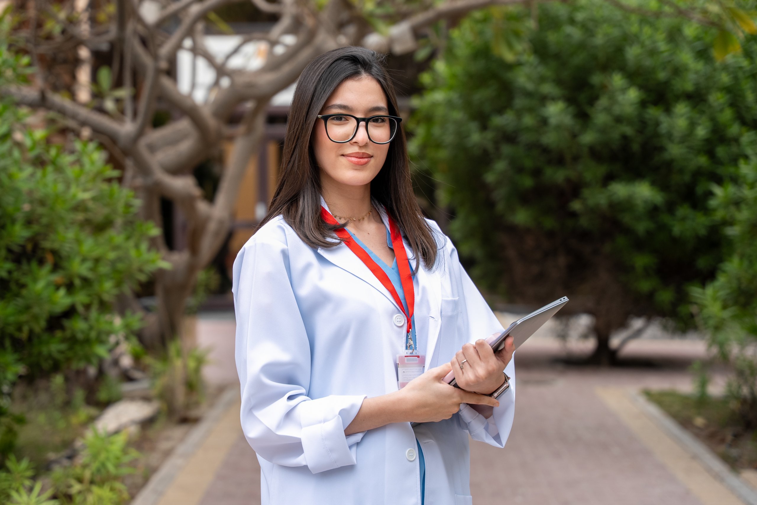 Student with iPad standing in a campus corridor